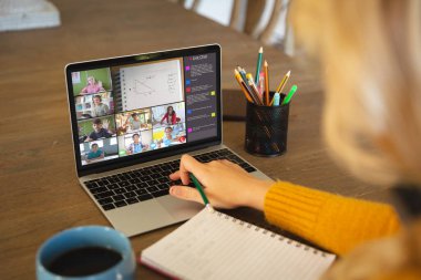 Beyaz bir kadın ekranda çeşitli ilkokul öğrencilerinin gülümsediği bir video görüşmesi için dizüstü bilgisayar kullanıyor. iletişim teknolojisi ve çevrimiçi eğitim, dijital kompozit resim.