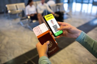 Elinde belgeler ve kovanlı 19 aşılı pasaportlu akıllı telefon olan bir kadın. küresel covid 19 salgın konsepti dijital olarak oluşturulmuş video.