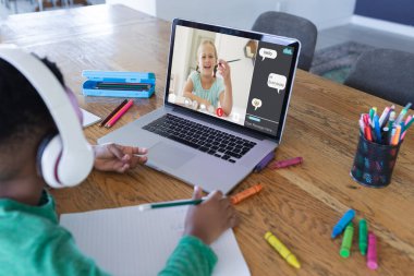 Ekranda gülümseyen ilkokul öğrencisiyle video görüşmesi için dizüstü bilgisayar kullanan Afrikalı Amerikalı çocuk. iletişim teknolojisi ve çevrimiçi eğitim, dijital kompozit resim.