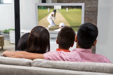 Mutlu aile kanepede televizyon izlerken arka görünümü