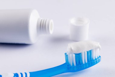 Beyaz yüzeyde diş fırçası ve diş macunu resmi. Sağlık, dişçilik, diş aksesuarları ve diş bakımı konsepti.