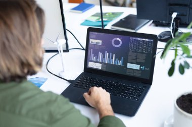 Kafkasyalı iş kadını ekranda grafik ve istatistiksel verilerle masada oturuyor. iş iletişimi ve dijital arayüz teknolojisi dijital kompozit görüntü.