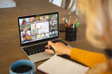 Beyaz bir kadın ekranda çeşitli ilkokul öğrencilerinin gülümsediği bir video görüşmesi için dizüstü bilgisayar kullanıyor. iletişim teknolojisi ve çevrimiçi eğitim, dijital kompozit resim.