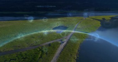 Manzaranın ortasındaki yolda ilerleyen aracın hava görüntüsü üzerinde bilgi arayüzü animasyonu. Dijital bileşik, çoklu pozlama, doğa, rapor, veritabanı ve teknoloji kavramı.