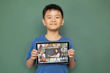 Çeşitli ilkokul öğrencileriyle video görüşmesi için elinde tablet olan gülümseyen Asyalı çocuk. iletişim teknolojisi ve çevrimiçi eğitim, dijital kompozit resim.