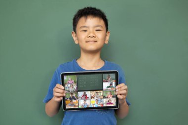 Çeşitli ilkokul öğrencileriyle video görüşmesi için elinde tablet olan gülümseyen Asyalı çocuk. iletişim teknolojisi ve çevrimiçi eğitim, dijital kompozit resim.