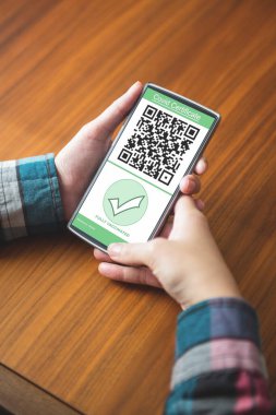 Masada oturan ve cep telefonu kısa mesaj yazarak kadın