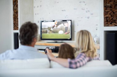 Evde oturup TV 'de futbol maçı izleyen aile görüntüsü. spor, rekabet, eğlence ve teknoloji konsepti dijital kompozit görüntü.