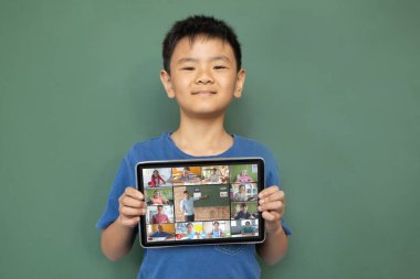 Çeşitli ilkokul öğrencileriyle video görüşmesi için elinde tablet olan gülümseyen Asyalı çocuk. iletişim teknolojisi ve çevrimiçi eğitim, dijital kompozit resim.