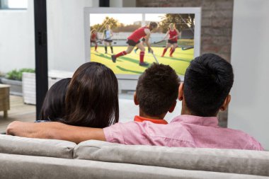 Mutlu aile kanepede televizyon izlerken arka görünümü