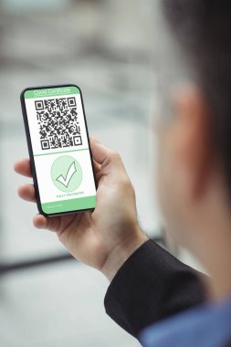 Elinde kovanlı 19 aşılı pasaportlu akıllı telefon tutan adam. küresel covid 19 salgın konsepti dijital olarak oluşturulmuş video.