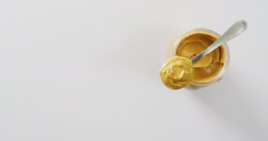 Beyaz arka planda fıstık ezmesi kavanozunun yakın çekim videosu. Yiyecek, parti ve fotokopi alanı.