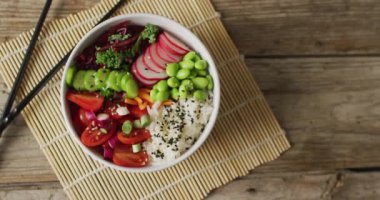 Ahşap zemin üzerinde yemek çubukları olan bir kase pirinç ve sebze kompozisyonu. Yiyecek, içecek ve renk konsepti.