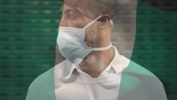 Animación Bandera Nigeria Ondeando Sobre Hombre Afroamericano Con Máscara Facial — Vídeo de stock