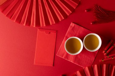 Kırmızı arka planda geleneksel Çin dekorasyonu ve hayranlarının kompozisyonu. Çin yeni yılı, gelenek ve kutlama konsepti.