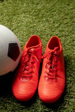 Spor stadyumunun ve fotokopi alanının üzerinde futbol ve ayakkabı kompozisyonu. Spor, hareket, eğitim ve aktif yaşam tarzı kavramı.