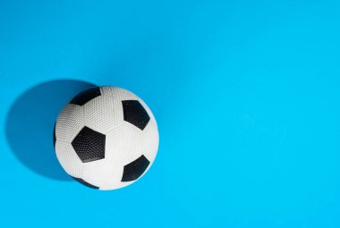 Mavi zemin üzerinde fotokopi alanı olan futbol kompozisyonu. Spor, hareket, eğitim ve aktif yaşam tarzı kavramı.