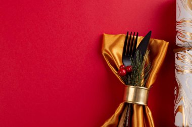 Çatal bıçak takımı, noel krakeri ve kırmızı arkaplanda fotokopi alanı. Noel, gelenek ve kutlama konsepti.