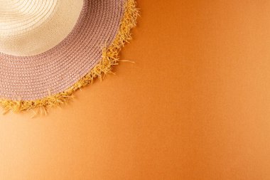 Sarı yüzeyde duran hasır şapkanın görüntüsü. Giysiler, tekstil, moda, tarz ve kıyafet konsepti.