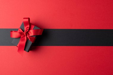 Gri ve pembe arkaplanlı pembe kurdeleli mevcut kompozisyon. Perakende, alışveriş ve Kara Cuma konsepti.