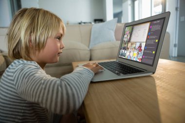 Beyaz çocuk ekranda çeşitli ilköğretim öğrencileri gülümserken görüntülü konuşma için laptop kullanıyor. iletişim teknolojisi ve çevrimiçi eğitim, dijital kompozit resim.