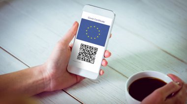 Oturma odasında evde kahve ile onun akıllı telefon kullanan kadın