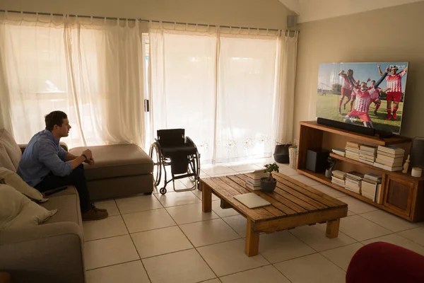 Homem Com Uma Deficiência Sentado Sofá Assistindo Jogo Futebol Futebol — Fotografia de Stock