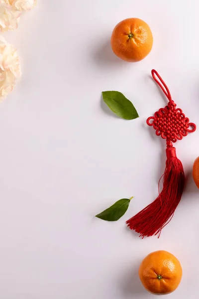 Composition of flowers, decorations and oranges on white background. Chinese new year, tradition and celebration concept.