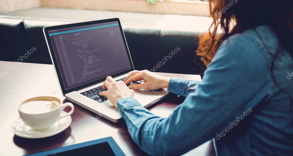 Caucasian female programmer sitting at desk with coffee, using laptop with coding on screen. coding, programming and computer technology digital composite image.