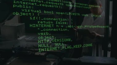 Fabrikada dijital tablet kullanan beyaz erkek mühendis üzerinde veri işleme animasyonu. Küresel iş ve mühendislik teknolojisi kavramı