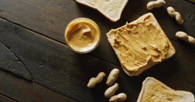 Ahşap arka planda fıstık ezmeli tost videosu. Yiyecek, parti ve fotokopi alanı.