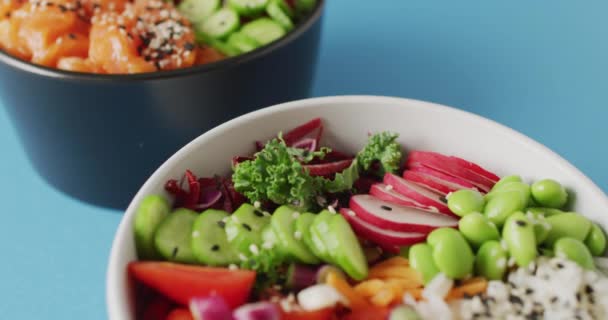 Összetétele Tálak Rizs Lazac Zöldségek Kék Alapon Élelmiszer Ital Színkoncepció — Stock videók