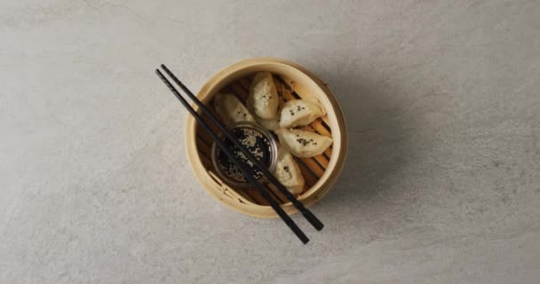 Composition Bamboo Steamer Gyoza Dumplings Chopsticks Soy Sauce Grey Background — Stock Video