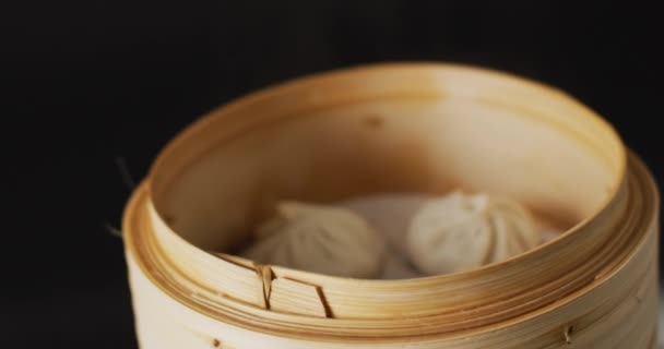 Hand Hålla Ätpinnar Med Dim Summa Dumpling Bambu Ångkokare Svart — Stockvideo