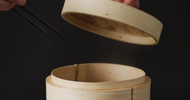 Hand Holding Chopsticks Gyoza Dumpling Bamboo Steamer Black Background Food — Stock Video