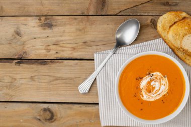Tahta masada kaşık ve tost ile domates çorbasının yatay görüntüsü, kopyalama alanı. Lezzetli ev yemekleri ve sağlıklı yemekler..