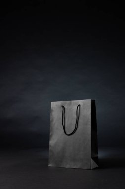 Gri arka planda gri kağıt alışveriş torbası kompozisyonu. Perakende, alışveriş ve Kara Cuma konsepti.