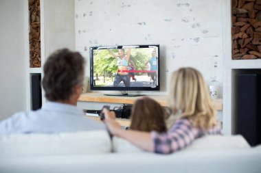 Ailesinin evde oturup TV 'de spor müsabakalarını izlediğini görmek. spor, rekabet, eğlence ve teknoloji konsepti dijital kompozit görüntü.
