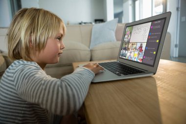Beyaz çocuk ekranda çeşitli ilköğretim öğrencileri gülümserken görüntülü konuşma için laptop kullanıyor. iletişim teknolojisi ve çevrimiçi eğitim, dijital kompozit resim.