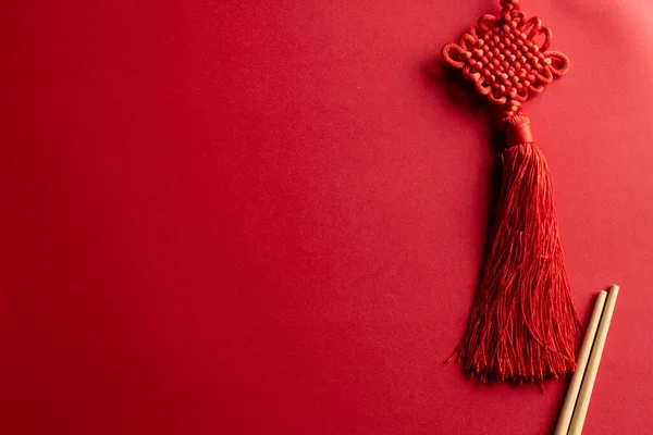 Composition of traditional chinese decorations and chopsticks on red background. Chinese new year, tradition and celebration concept.