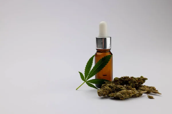 白い表面にCbd油と乾燥マリフアナの葉のボトルのイメージ Cbdオイル 医療用マリファナ 大麻医学の概念 — ストック写真