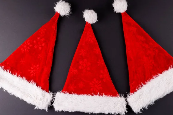 Εικόνα Των Καπέλων Santa Claus Που Βρίσκονται Σκούρο Γκρι Επιφάνεια — Φωτογραφία Αρχείου