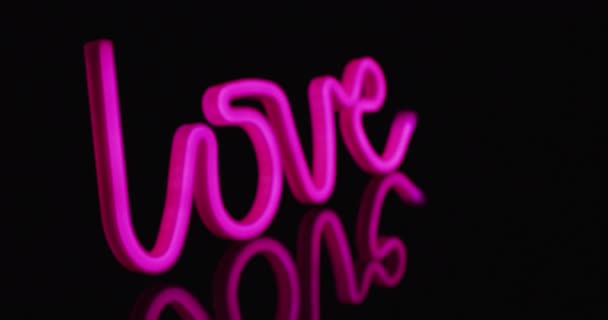粉色霓虹灯的动画在黑色背景上形成了爱的文字 版权和色彩概念 — 图库视频影像