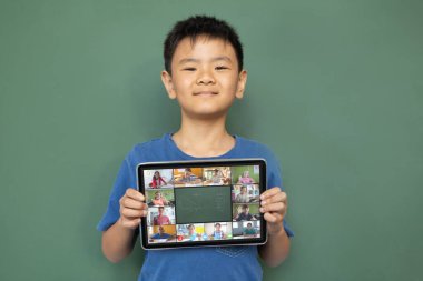 Çeşitli ilkokul öğrencileriyle video görüşmesi için elinde tablet olan gülümseyen Asyalı çocuk. iletişim teknolojisi ve çevrimiçi eğitim, dijital kompozit resim.