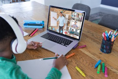 Ekranda farklı ilkokul öğrencileri olan Afro-Amerikan çocuk, video görüşmesi için dizüstü bilgisayar kullanıyor. iletişim teknolojisi ve çevrimiçi eğitim, dijital kompozit resim.