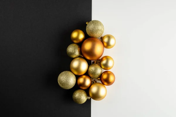 Composition of close up of new years baubles on black and white background. New year's eve party, celebration and copy space concept.