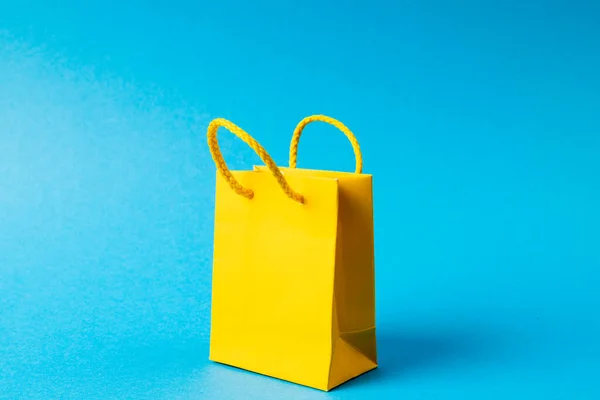 Samenstelling Van Gele Papieren Boodschappentas Blauwe Achtergrond Detailhandel Winkelen Zwarte — Stockfoto