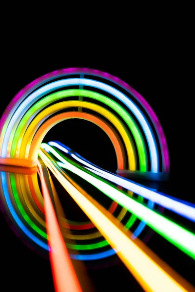 Image of vibrant neon glow sticks forming rainbow over black background with copy space. Lgbt, equality, love, light and colour concept.