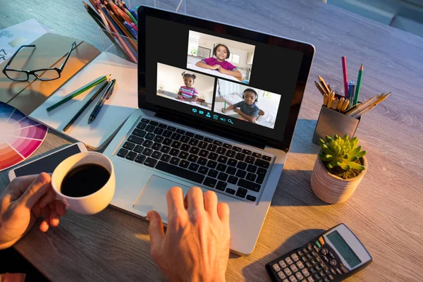 Adamın elleri ekranda çeşitli ilkokul öğrencilerinin gülümsediği bir video görüşmesi için dizüstü bilgisayar kullanıyor. iletişim teknolojisi ve çevrimiçi eğitim, dijital kompozit resim.
