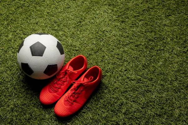 Spor stadyumunun ve fotokopi alanının üzerinde futbol ve ayakkabı kompozisyonu. Spor, hareket, eğitim ve aktif yaşam tarzı kavramı.